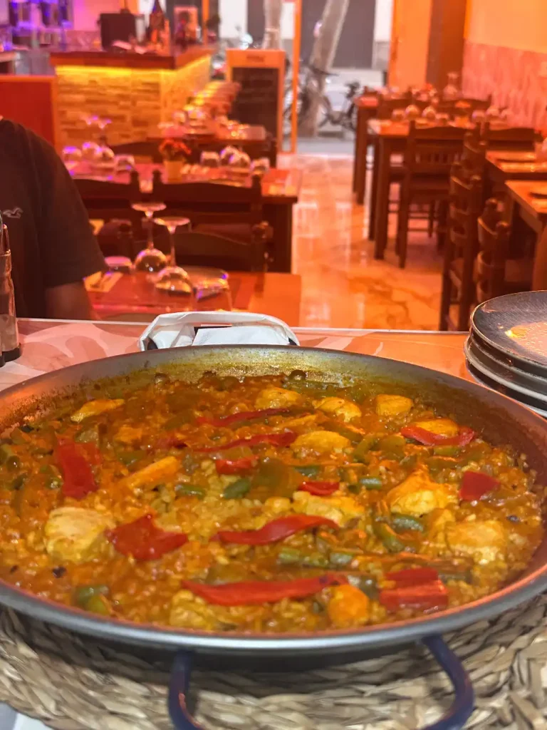 Paella de verduras con pimientos rojos y verdes servida en el comedor de Tastari